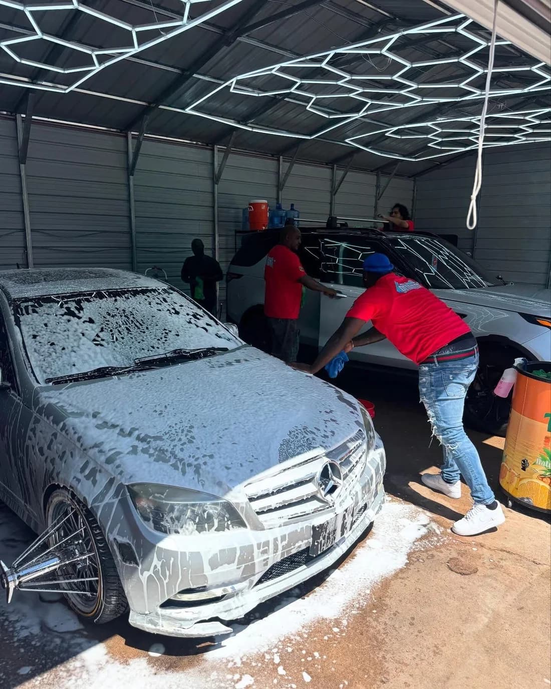 The Faevaa team hand-washing a foam-covered Mercedes inside the Homestead Road detail bay